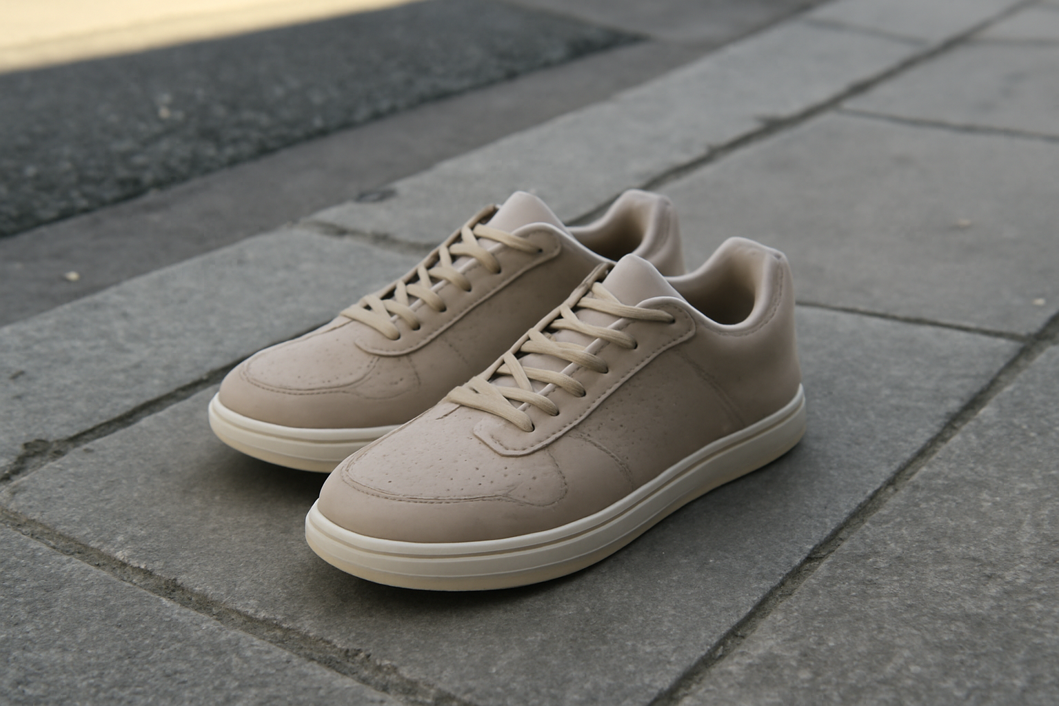 paire de sneakers posée sur trottoir urbain