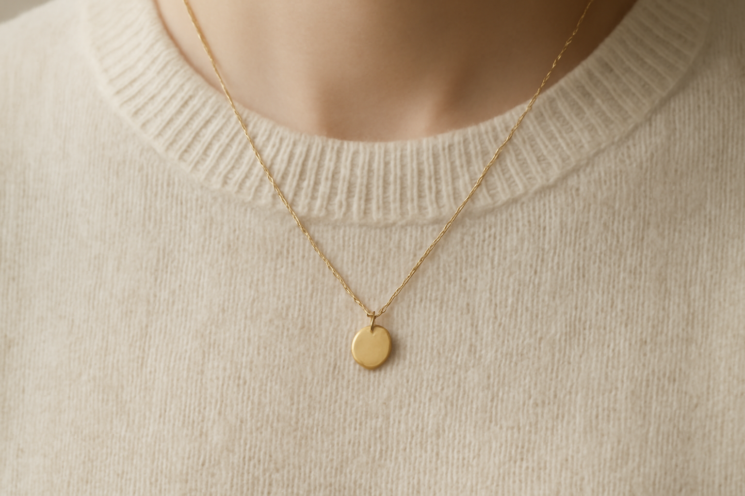 collier délicat sur pull monochrome