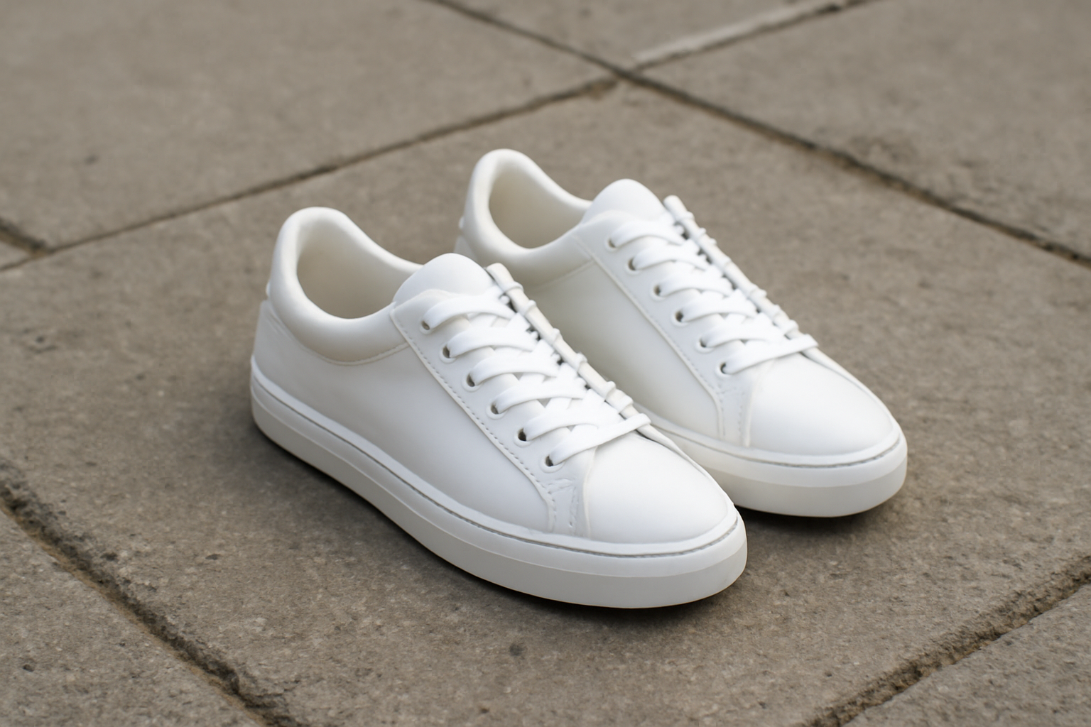 paire de baskets blanches sur trottoir