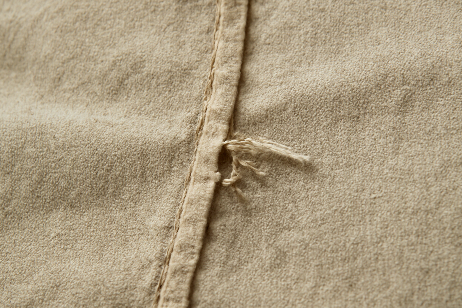 tendancemagasin-coutures-effilochent-vetement-neuf gros plan sur couture defaillante d'un tissu