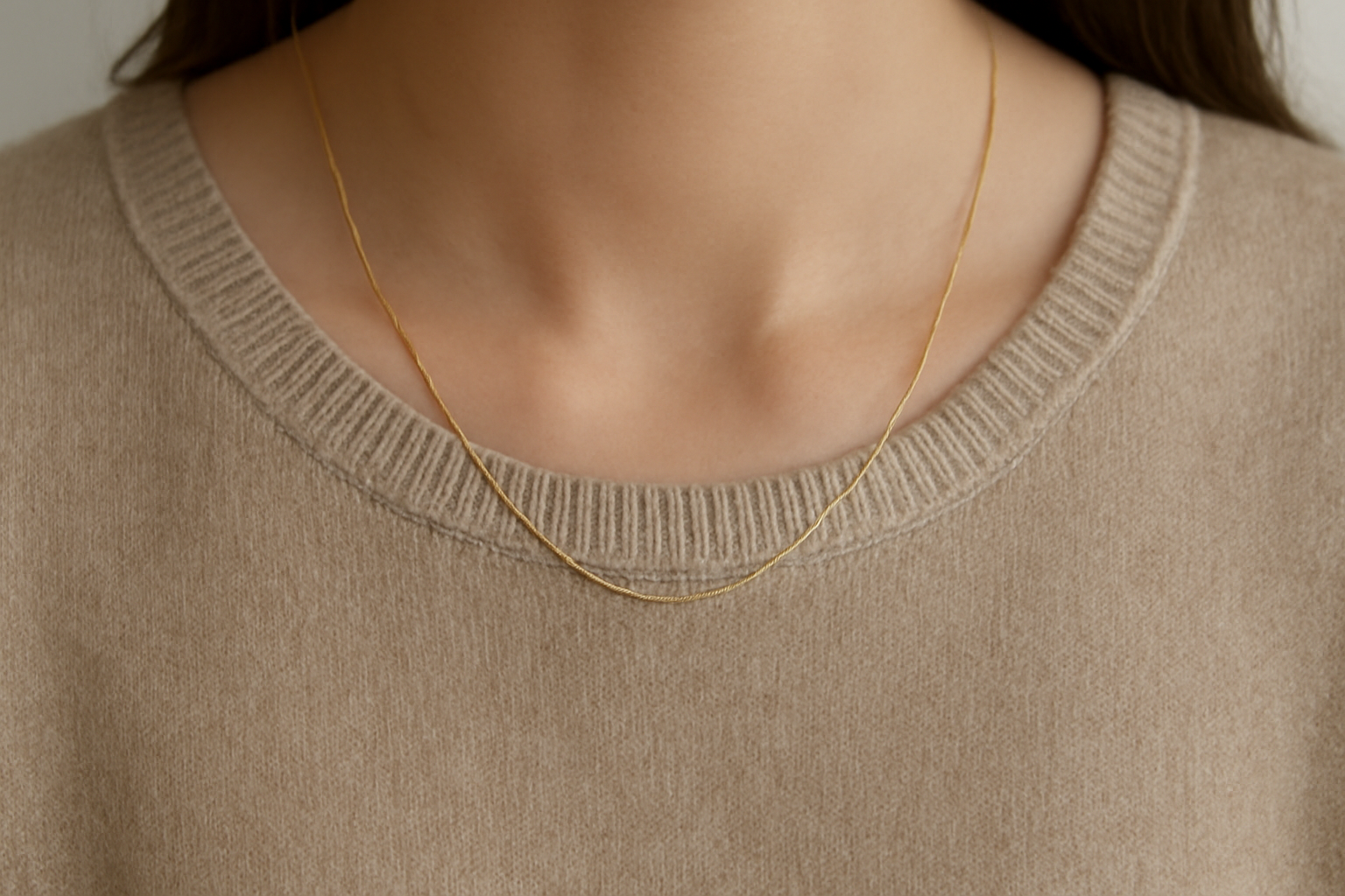 collier discret sur un pull monochrome